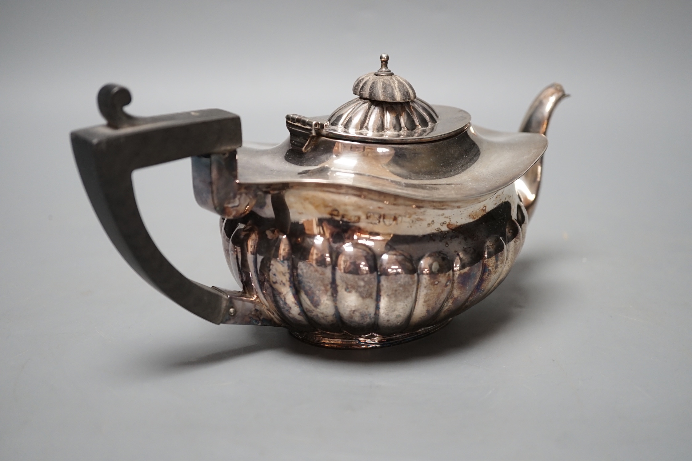 A late Victorian demi-fluted silver teapot, Chester, 1898, gross 10oz.